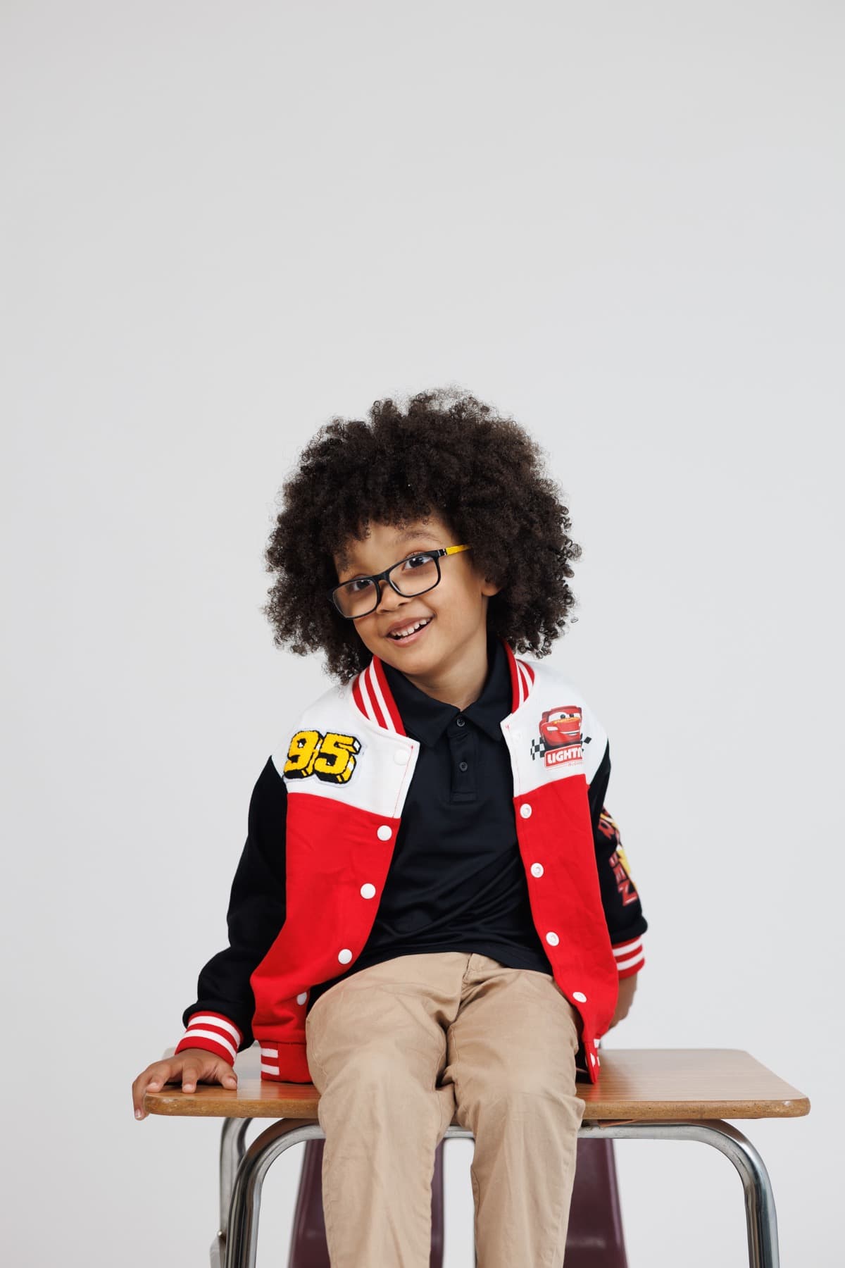 A portrait of the founder's son sitting proudly in a Cars jacket.